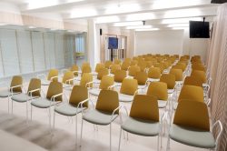 Sala polivalent amb cadires preparades per a una presentació o acte.
