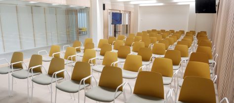 Sala polivalent amb cadires preparades per a una presentació o acte.